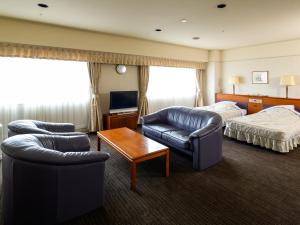 une chambre d'hôtel avec un canapé et un lit dans l'établissement Grand Mercure Nara Kashihara, à Kashihara