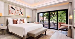 a bedroom with a white bed and a balcony at The St. Regis Goa Resort in Cavelossim