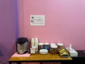 a table with a coffee maker and food on it at Madam Guesthouse in Krabi town