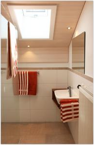 een badkamer met een wastafel en een dakraam bij Ferienwohnungen Gastager in Ruhpolding