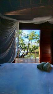 a bedroom with a bed and a window with a tree at Villa Luzo in Saonek