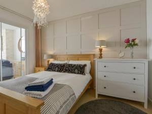 a bedroom with a white bed with a dresser and a drawer at Red Peg in Kingsand