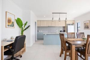 una cucina e una sala da pranzo con tavolo e sedie di “Brand New Home” Central Charm at Hervey Bay a Urraween