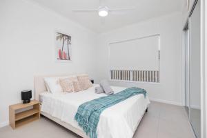 una camera bianca con un letto e una finestra di “Brand New Home” Central Charm at Hervey Bay a Urraween