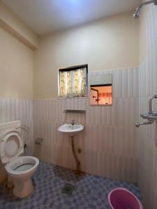 a bathroom with a toilet and a sink at Hotel BhupuSainik Sauraha in Sauraha