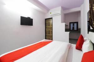 a bedroom with a bed with a tv on the wall at Kastle Guest House in New Delhi