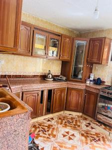 a kitchen with wooden cabinets and a tile floor at Nabatean NIghts Home Stay in Wadi Musa