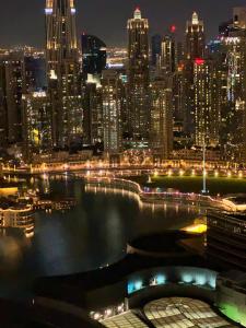 a view of a city skyline at night at Emaar Fashion avenue-Formerly The Address Dubai Mall residence - Downtown by Suitestay Homes in Dubai