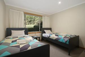 布赖特Greenlea的有两张床和一扇窗户的卧室