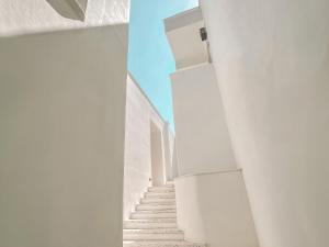 una escalera en un edificio blanco con paredes blancas en Perios Beach House - Adults Only, en Turunç