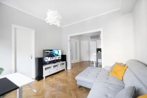 a living room with a couch and a tv at Your Deluxe Home in Bucharest center in Bucharest