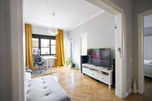 a living room with a couch and a flat screen tv at Your Deluxe Home in Bucharest center in Bucharest