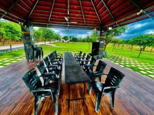 a group of tables and chairs on a wooden deck at MPN RESORTS AND HOTELS PRIVATE LIMITED in Hyderabad