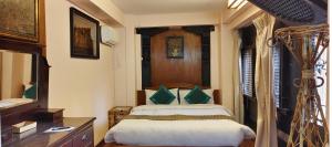 ein Schlafzimmer mit einem Bett, einer Kommode und einem Spiegel in der Unterkunft Halyo suite room Greentara Heritage Home by Tranquil home in Pātan