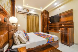 um quarto de hotel com uma cama e uma televisão de ecrã plano em FabHotel Icon em Patna