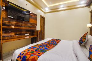 a bedroom with a bed and a flat screen tv at FabHotel Icon in Patna