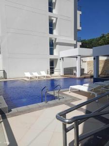 a swimming pool with chairs and a building at Ocean Garden Villa Condominium in Boracay