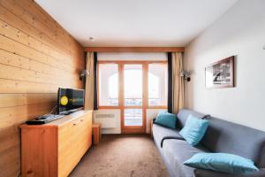 ein Wohnzimmer mit einem Sofa und einem TV in der Unterkunft Résidence La Marelle et Le Rami - maeva Home - Studio 4 Personnes - Sélecti 00 in La Plagne Tarentaise
