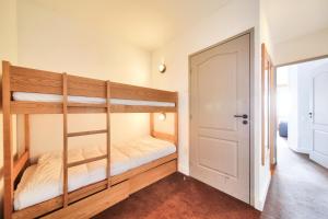 1 Schlafzimmer mit 2 Etagenbetten und einer Tür in der Unterkunft Résidence La Marelle et Le Rami - maeva Home - Studio 4 Personnes - Sélecti 00 in La Plagne Tarentaise