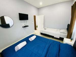 1 dormitorio con 1 cama azul, 1 cama y espejo en Patteera Pool Villa Sattahip en Sattahip