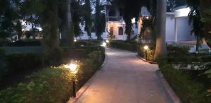 une passerelle devant une maison la nuit dans l'établissement The Baagh Jungle Resort, à Khajurâho