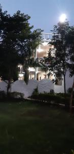 un gran edificio blanco con árboles delante de él en The Baagh Jungle Resort, en Khajurāho