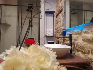 un mostrador con un tazón y flores en una mesa en Via Mazzini Home, en Gubbio