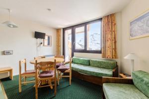 a hotel room with a table and a couch at Résidence Les Alpages - maeva Home - Studio 4 Personnes Budget 84 in Morzine