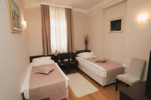 a room with two beds and a chair and a window at Sobe Bernarda in Varaždinske Toplice +58 photos