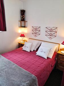 een slaapkamer met een bed met rode lakens en witte kussens bij Résidence Les Sentiers du Tueda - maeva Home - 2 Pièces 4 Personnes Confort 45 in Les Allues