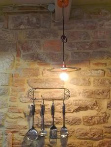 un lampadario a braccio con forchette e cucchiai appesi a un muro di Via Mazzini Home a Gubbio