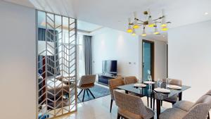 a dining room with a table and chairs and a television at Primestay - 2BR Damac Prive in Business Bay in Dubai