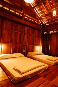 Homestay A Ngưi في De Dang (1): سريرين في غرفة بجدران خشبية