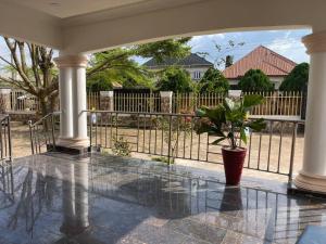 een veranda met een potplant voor een hek bij 3-bedroom bungalow. Free parking on the premises. in Benin City