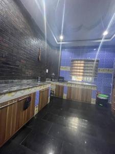 een lege keuken met een bakstenen muur en blauwe tegels bij 3-bedroom bungalow. Free parking on the premises. in Benin City