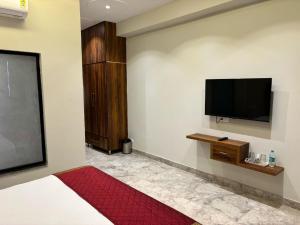 1 dormitorio con TV de pantalla plana en la pared en Siswan View Hotel, en Khizrābād