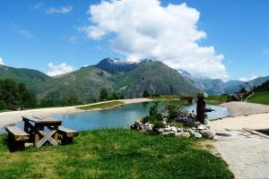 a bench sitting next to a lake with mountains at Appartement 6 pers. pied des pistes 68969 in Les Deux Alpes