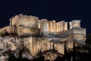 a castle on top of a mountain at night at Xenia's Cozy Apartment (near Acropolis Museum) in Athens