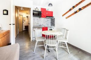 cocina y comedor con mesa y sillas en Studio 4 pers. pied des pistes - Maeva Particuliers 69572, en L'Alpe-d'Huez