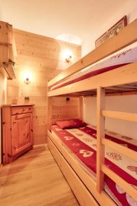 ein Schlafzimmer mit Etagenbetten in einem Blockhaus in der Unterkunft Les Résidences de Valmorel - maeva Home - 2 Pièces 4 Personnes Confort 58 in Valmorel