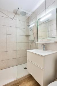 y baño blanco con lavabo y ducha. en Les Résidences de Valmorel - maeva Home - 2 Pièces 4 Personnes Confort 58, en Valmorel