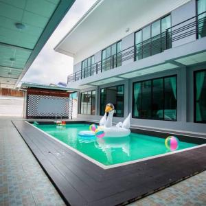 a swimming pool with a swan in the middle of a building at Three Bridges Hotel in Nan