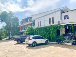 a white car parked in a parking lot next to a building at Three Bridges Hotel in Nan