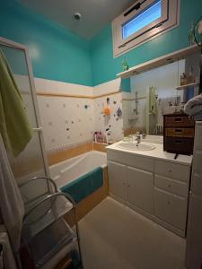 a bathroom with a tub and a sink and a mirror at PARENTHÈSE Chambre Cosy proche Centre et Gare in Angoulême