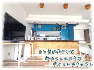 een woonkamer met een tv en een tafel bij ワンハウスatワニベース in Otsu