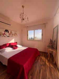 エピスコピ・レメソスにあるROSE VILLA - 3 BED POOLの赤い毛布が掛けられた大きなベッドのある寝室