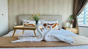 dois cisnes transformados em toalhas numa cama em Mutiara Melaka Beach Resort by Glex em Tangga Batu