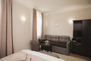 a hotel room with a couch and a television at Sobe Bernarda in Varaždinske Toplice