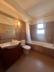 La salle de bains est pourvue d'un lavabo, de toilettes et d'une baignoire. dans l'établissement ROSE VILLA - 3 BED POOL, à Episkopí