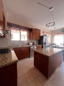 - une cuisine avec des placards en bois et un comptoir dans l'établissement ROSE VILLA - 3 BED POOL, à Episkopí